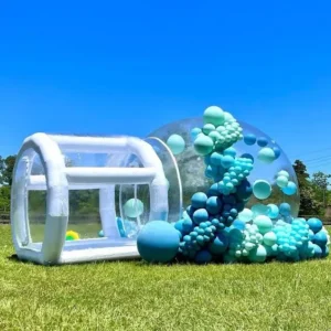 Burbuja inflable para jardín decorada con globos de colores llamativos, colocada dentro de una sección al aire libre de una casa.
