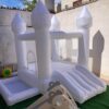 Castillo inflable blanco con cuatro torres, resbaladilla frontal y alberca de pelotas.