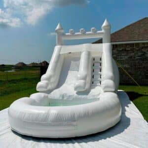 castillo inflable blanco con doble resbaladilla y alberca frontal.