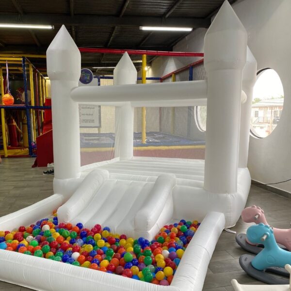 Castillo inflable blanco decorado con globos, ideal para fiestas infantiles y eventos especiales