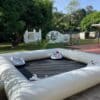 Pista inflable para bumper cars blancos en exterior con castillo inflable y burbuja decorativa al fondo.