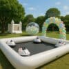 Pista inflable para bumper cars blancos en exterior con castillo inflable y burbuja decorativa al fondo.
